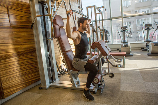 Handsome Man Exercising On Lat Pull Down Machine