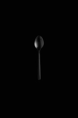 isolated black tea spoon on black background 