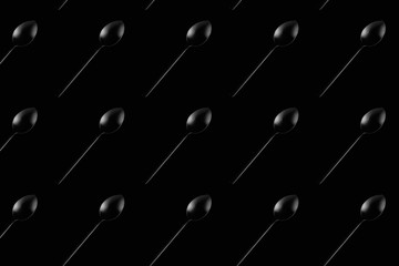 isolated black spoon on black background texture horizontal