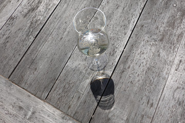 Wine glass and its shade on a wooden table, close up for concept