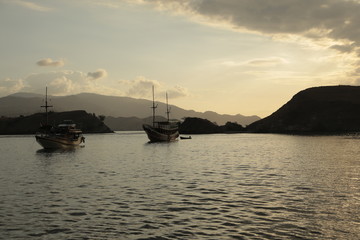 Fototapeta premium Two ship sailing together at sunset in the sea of Bali