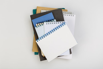 stack of colorful notebooks with pen isolated on white background