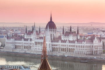 Fototapeta na wymiar Panoramic cityscape of Hungarian parliament building on the Danube river. Colorful sunrise in Budapest, Hungary
