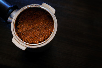 Portafilter for a coffee machine filled with ground coffee.