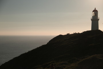 Fototapeta na wymiar Sea horizon with light house on top of the hill