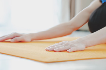 Obraz na płótnie Canvas Yoga meditation wellness concept - woman doing childs pose stretch on exercise mat - training fitness class at home or gym active living.