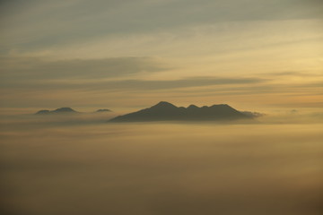 Fototapeta na wymiar Mountain top over the clouds on sunrise