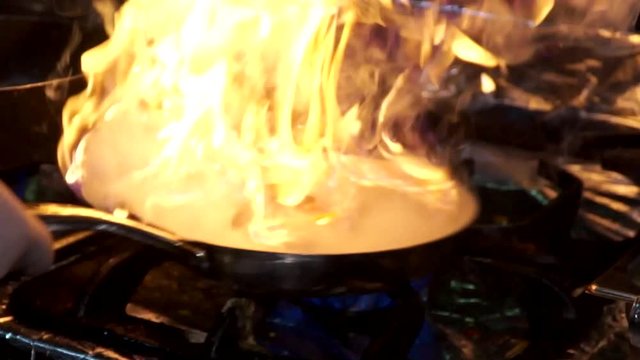 Chef is cooking in the pan in the restaurant 