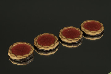 Cake with jam on a red mirror background