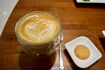 A cup of coffee and a cookie at a cafe in Bangkok.