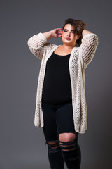 Plus size fashion model in casual clothes, fat woman on gray background