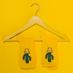 yellow socks with a pattern of cacti on a yellow hanger for clothes, concept