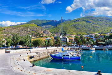 Fototapeta na wymiar Scenic view of the bay and pier Loutraki, Greece, where small fishing schooners, yachts, boats and boats moored in the clear waters of the Ionian Sea.