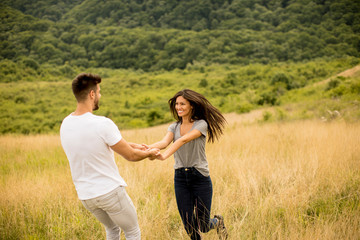 Young couple in love walking through grass field