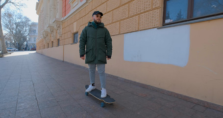 Young male ride on longboard skate on the streets