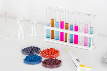 Herbicide-treated sunflower and corn seeds in a Petri dish on a table with a dispenser and test tubes