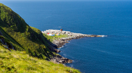 Obraz premium Runde lighthouse and buildings at Runde bird cliffs in Alesund, Norway during summer holiday.