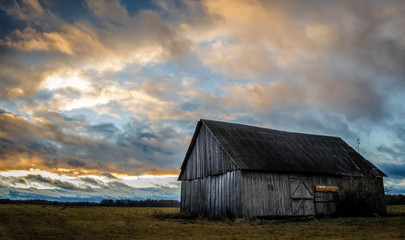 Fototapeta na wymiar Old wood barn in a middle of a field