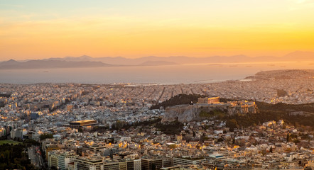 Fototapeta premium Panoramic sunset view of Athens, Greece, with Acropolis hill and Piraeus port at Saronic Gulf of Aegean sea in background seen from Lycabettus hill