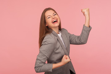 Yes I did it! Portrait of successful enthusiastic young woman in business suit screaming for joy...
