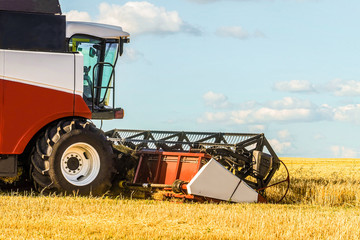 Combine harvester with cutter platform at work. Side view of reaping machine.