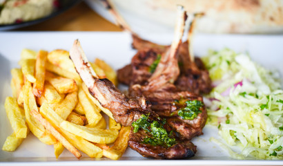 delicious grilled lamb chopsticks with french fries, pesto sauce & mix of lettuces