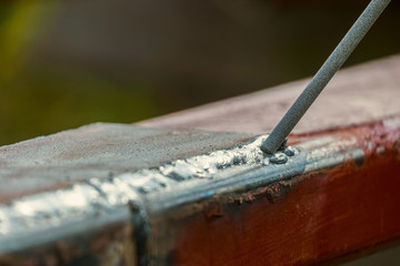 Weld on a metal profile and a welding electrode. Selective focus with limited depth of field.