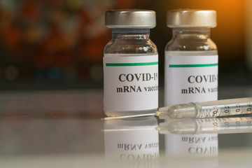 COVID-19 mRNA Vaccine and syringe with needle injection. It use for prevention, immunization and...