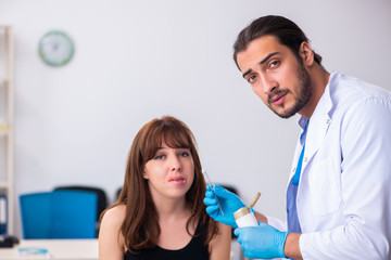 Fototapeta premium Young woman visiting male doctor dermatologist