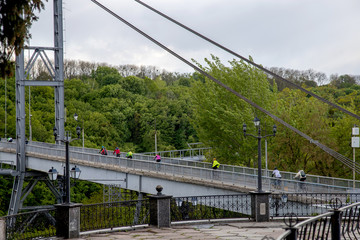 cyclists ride on a suspension bridge