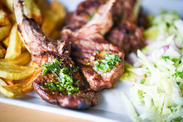 delicious grilled lamb chopsticks with french fries, pesto sauce & mix of lettuces