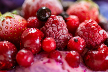 Close up of frozen berries on a cyan background. Cold summer fruit close-up.