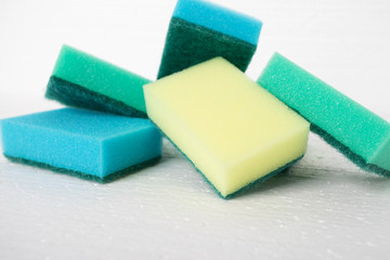 Cleaning furniture, carpets, floor coverings. Colorful sponges on a white background