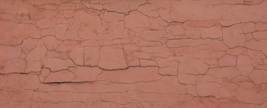 Pink wall with cracked plaste
