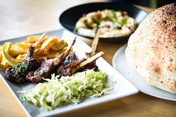 delicious grilled lamb chopsticks with french fries, pesto sauce & mix of lettuces