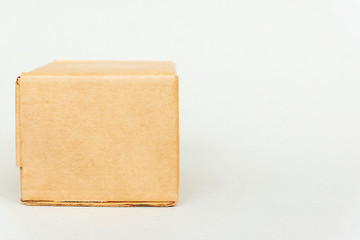 Closed cardboard box on table on white backdrop. Packaging, online shopping and delivery of goods from online stores
