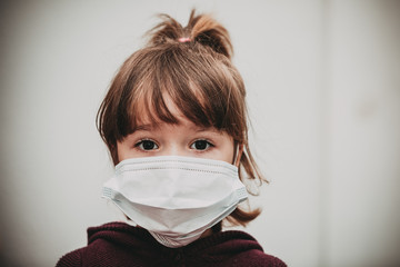 Girl with serious gesture wearing a mask to avoid getting COVID-19