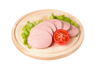 Boiled sausage, cut into slices on a board. Near lettuce leaf and tomato