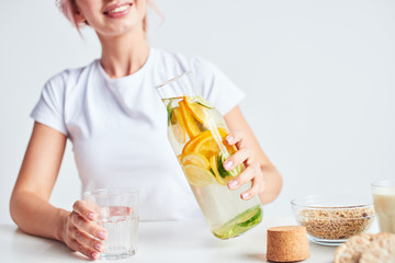 Woman making fresh citrus water with lemon, lime and orange