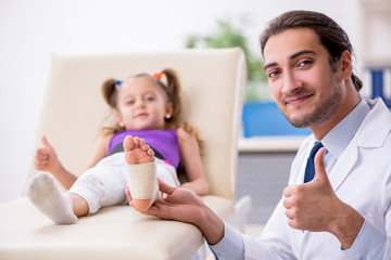 Small girl visiting young male doctor