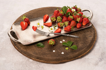 strawberries on a wooden on a spacing with a fork on a dark background top view.