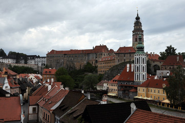 Fototapeta na wymiar Panorama of the high walls of the castle, tower and church of St. Vitus in the historic city of Cesky Krumlov. View from the seminary park.