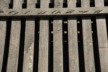 Wooden provincial fence with nails leaning back