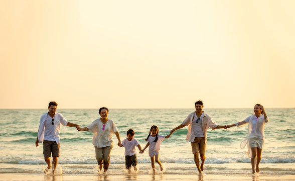 Group Of Happy Multi Generation Asian Family Relax And Having Fun Together On Tropical Beach In Summertime. Smiling Big Family Parents With Child Boy And Girl Enjoy In Summer Lifestyle Travel Vacation