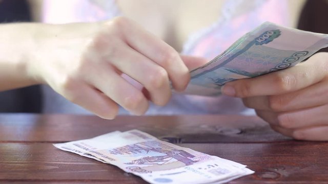 A woman in her underwear counts money. Sexy girl in a bra works at home. Freelance. Affectionate, breast, sensual, intimate, naked, client, pay, cash, erotic, boudoir, escort. Russian rouble. 
