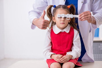 Small girl visiting young male doctor oculist