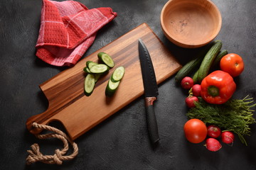 Cutting vegetables on a kitchen board. Preparing or cooking salad
