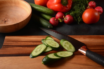 Cutting vegetables on a kitchen board. Preparing or cooking salad
