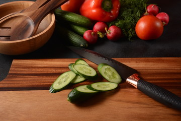 Cutting vegetables on a kitchen board. Preparing or cooking salad
