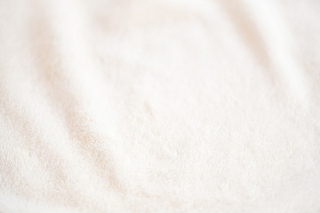 Fototapeta na wymiar Soft cozy plaid made of white fabric with a pile lies in beautiful folds